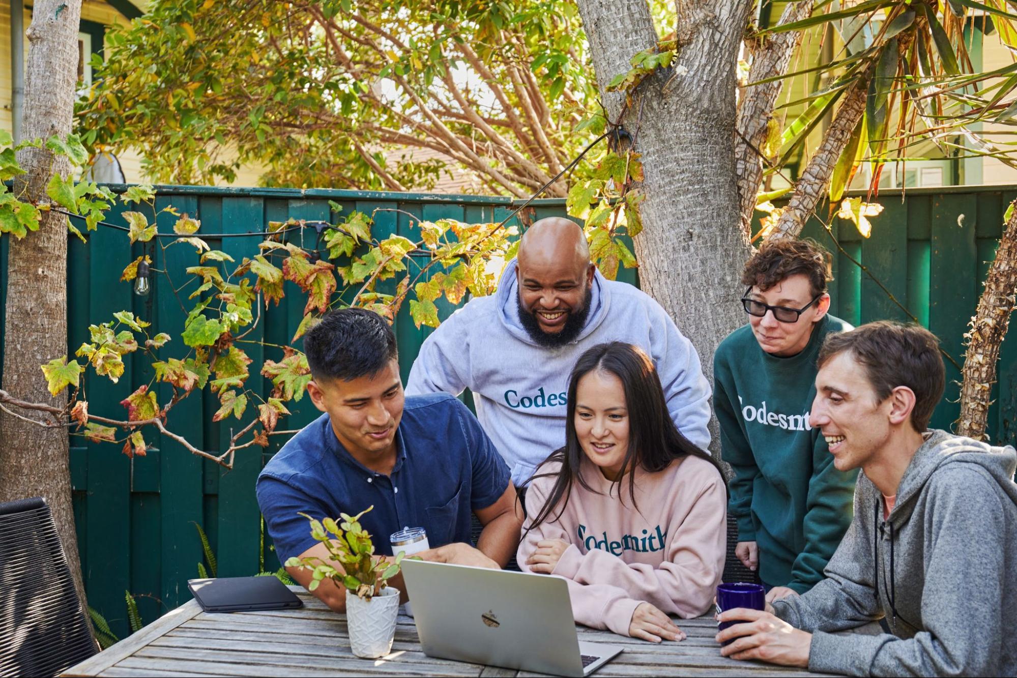 Codesmith learners collaborating around laptops
